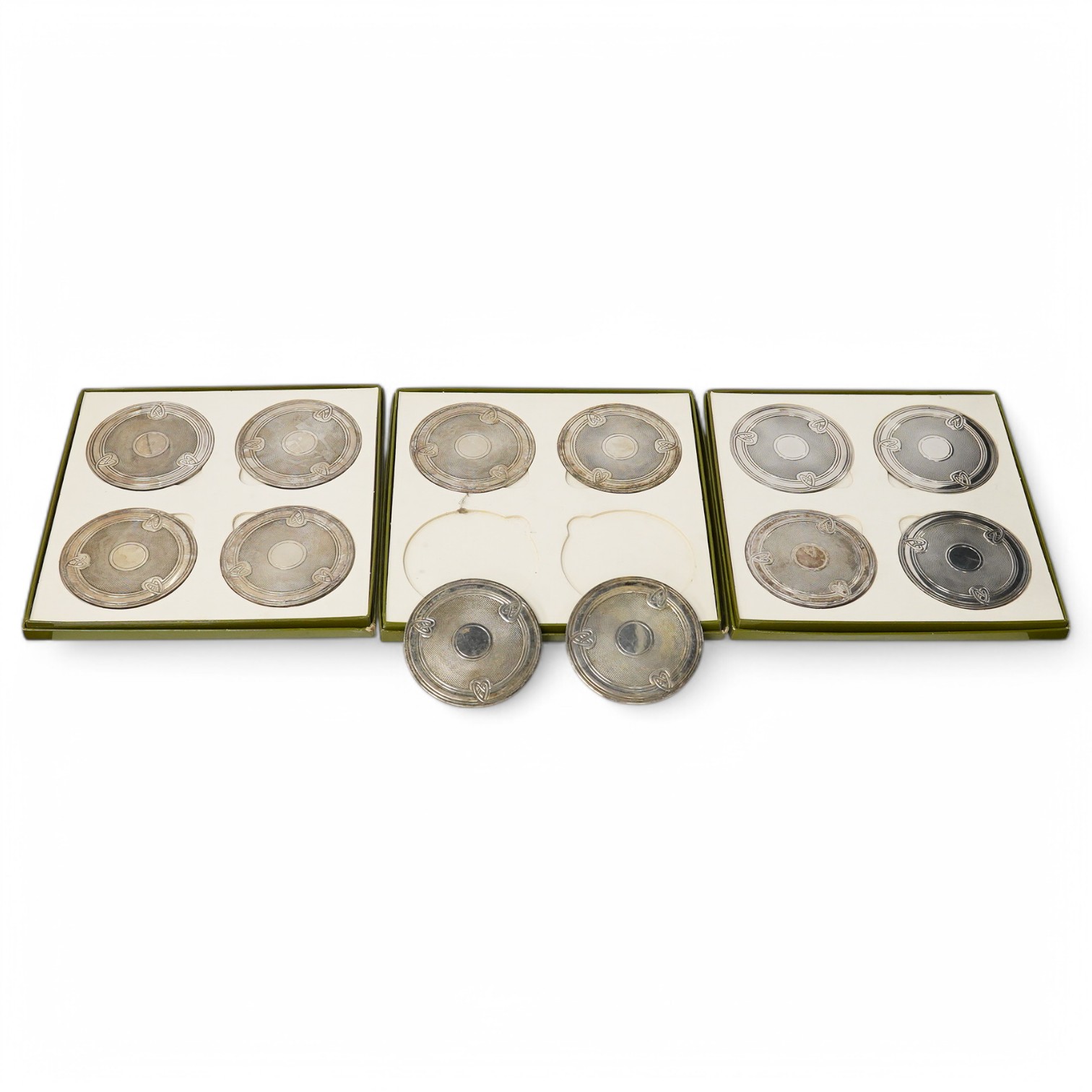 Twelve Christofle silver plated decorative wine coasters, in three boxes, 9cm diameter. Condition - slightly tarnished